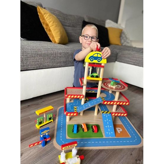 Garage en bois de Tomi avec ascenseur, petites voitures et hélicoptère